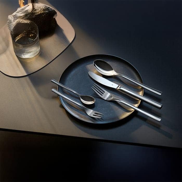 WMF Palermo 30-piece cutlery set with stainless steel knives, forks, and spoons arranged on a wooden table.