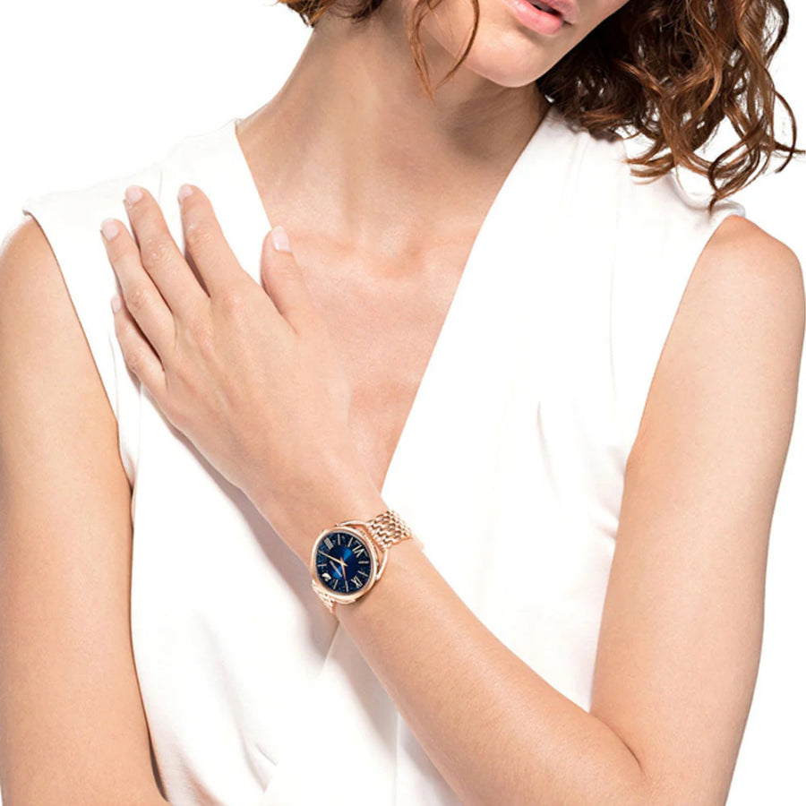 Swarovski Crystalline Glam Watch with blue face, rose-gold PVD metal bracelet, sparkling crystals, elegant and stylish accessory.