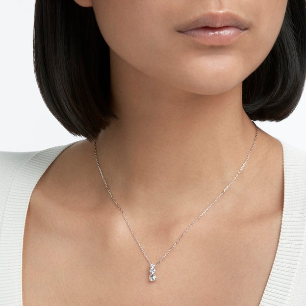 Swarovski Stilla Attract pendant with round cut white crystal, rhodium plated jewelry piece hanging on a chain.