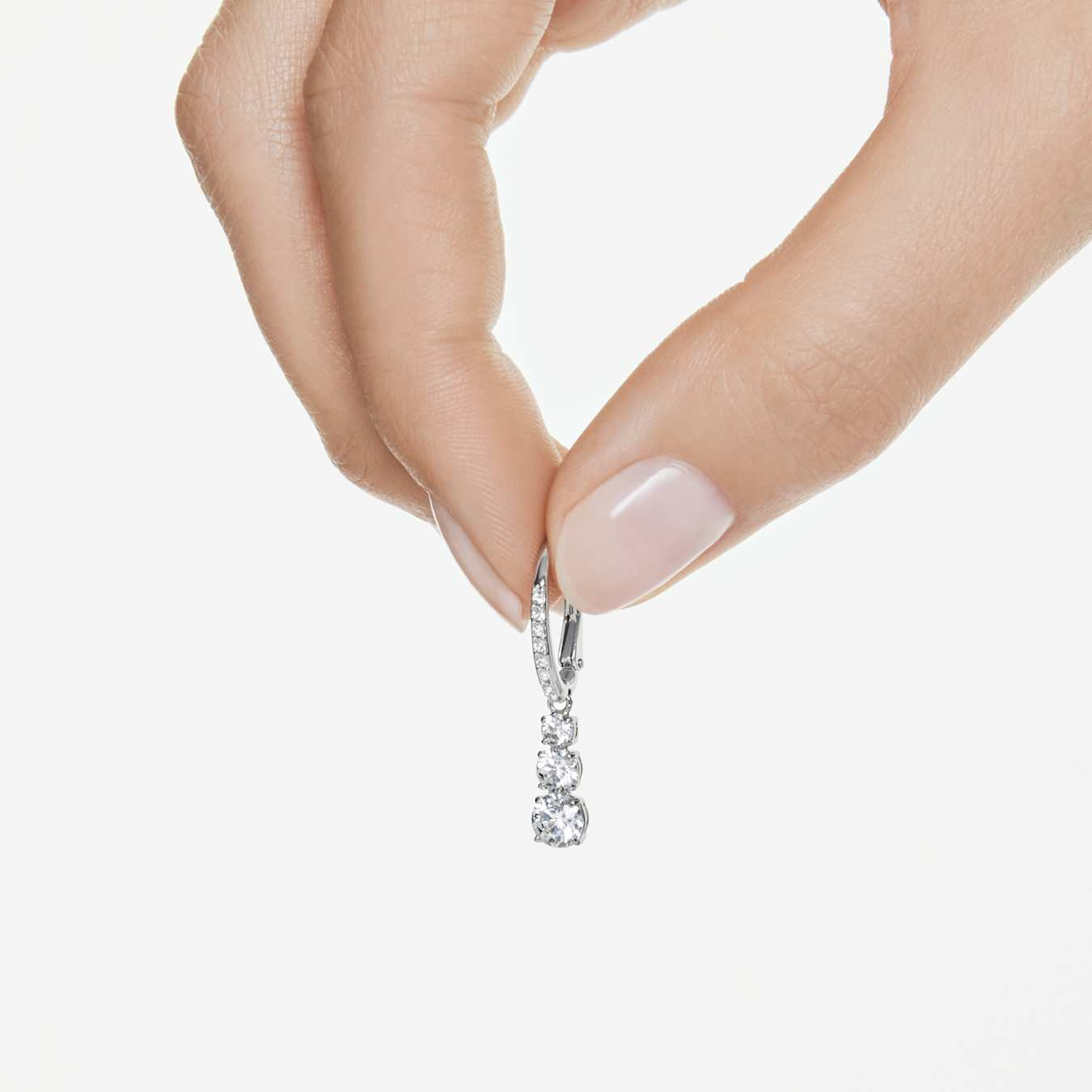 Swarovski Stilla Attract hoop earrings with round white crystals and rhodium plating, showcasing elegant jewelry design.