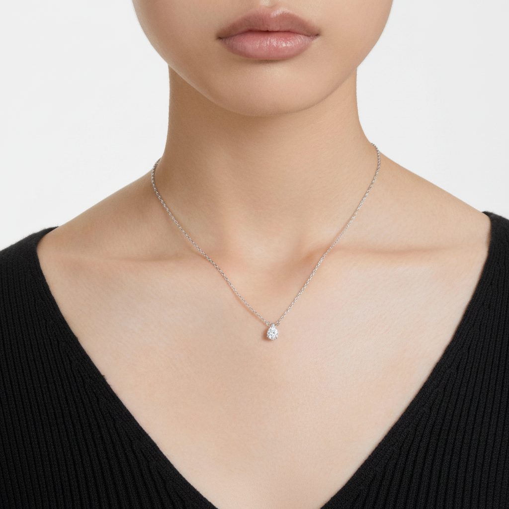 Swarovski Stilla pendant with pear-shaped white crystal, rhodium-plated silver setting, elegant jewelry accessory.