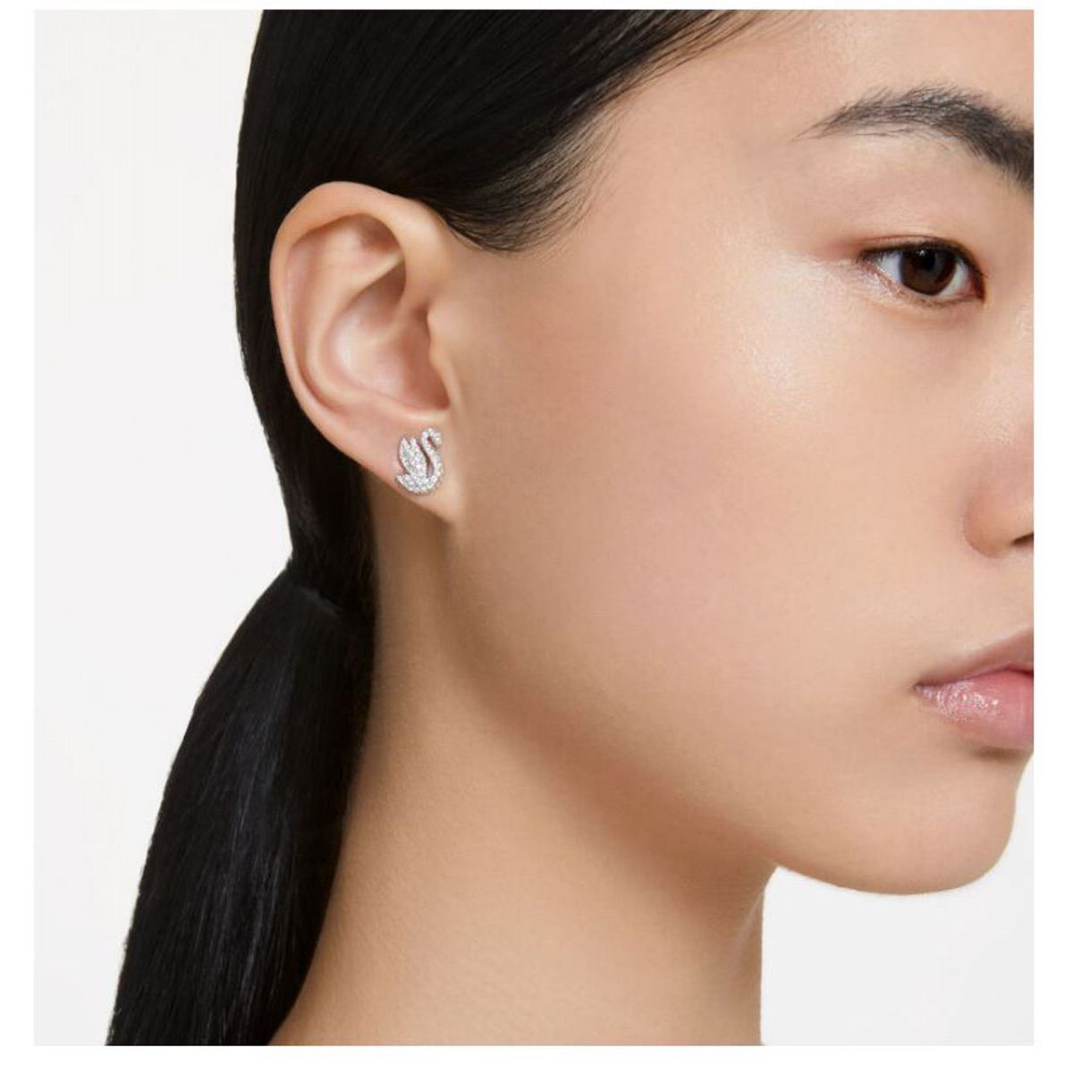 Swarovski Iconic Swan XXS earrings in clear crystal with silver-tone accents, featuring a sleek, elegant swan design.