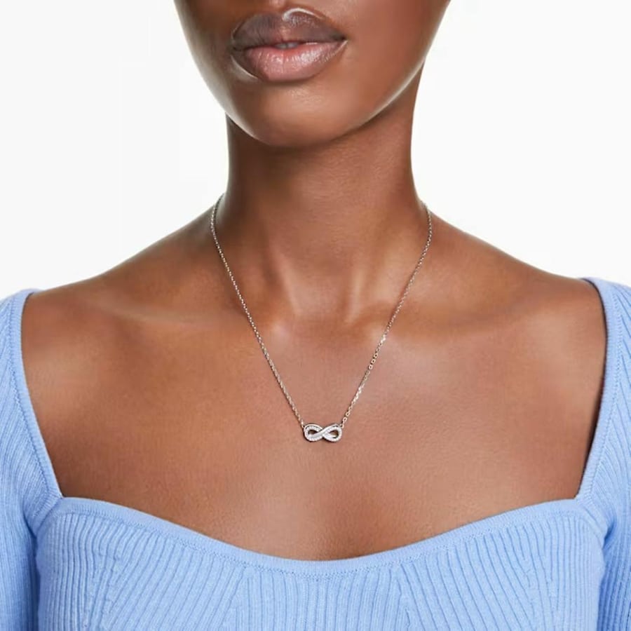 Swarovski Hyperbola Pendant Pavé with infinity design, white crystals, rhodium plating, hanging on a delicate chain.