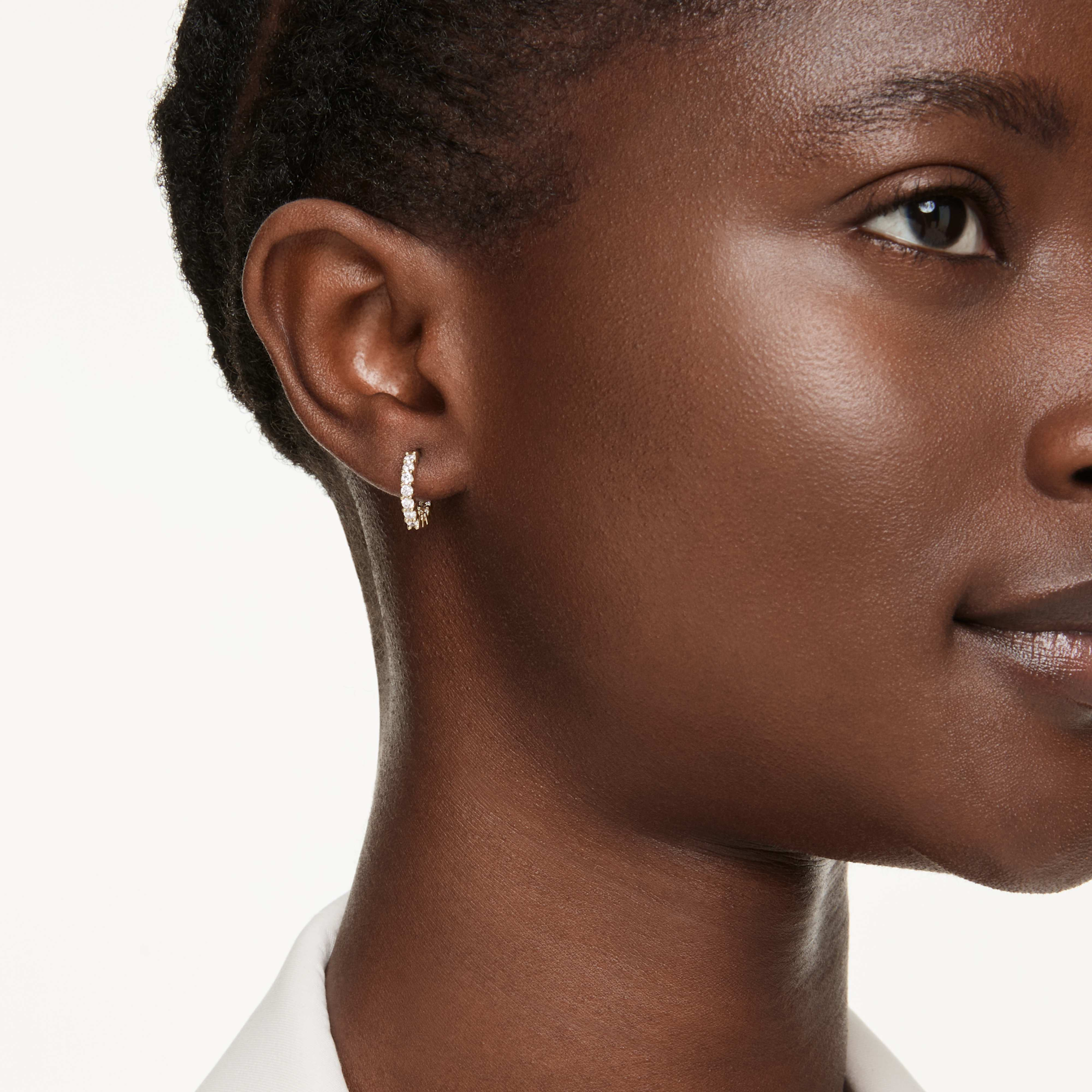 Swarovski Matrix Vittore hoop earrings with round cut white stones and gold-tone plating, showcasing elegant jewelry design.