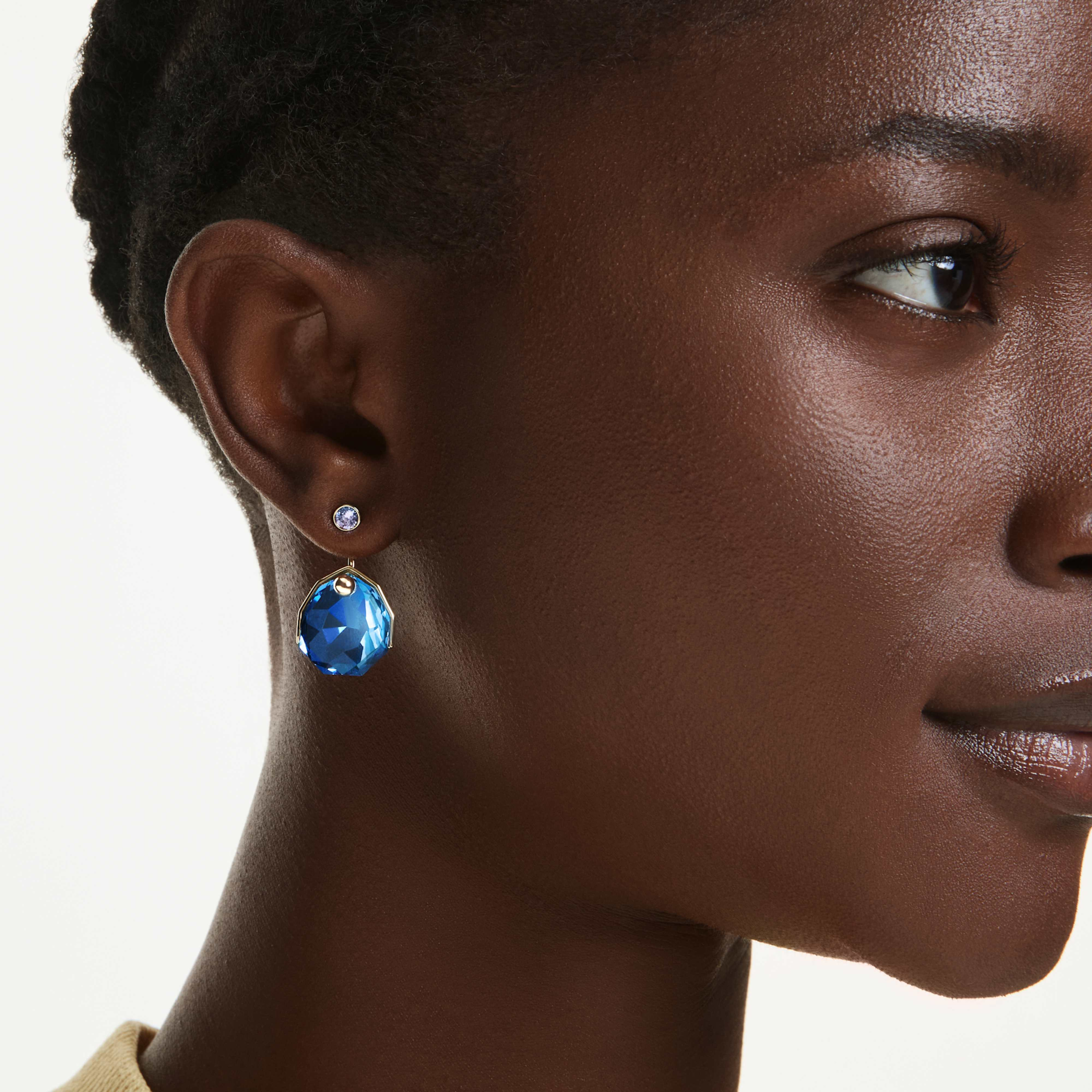 Swarovski Gema blue earring jackets in gold-tone plating, showcasing elegant jewelry design with sparkling blue accents.