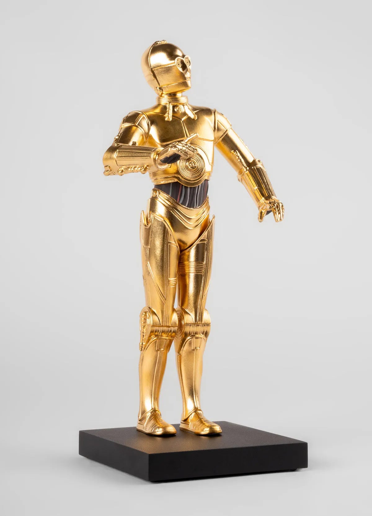 Lladro C3PO™ sculpture depicting the iconic gold android from Star Wars, detailed porcelain craftsmanship.