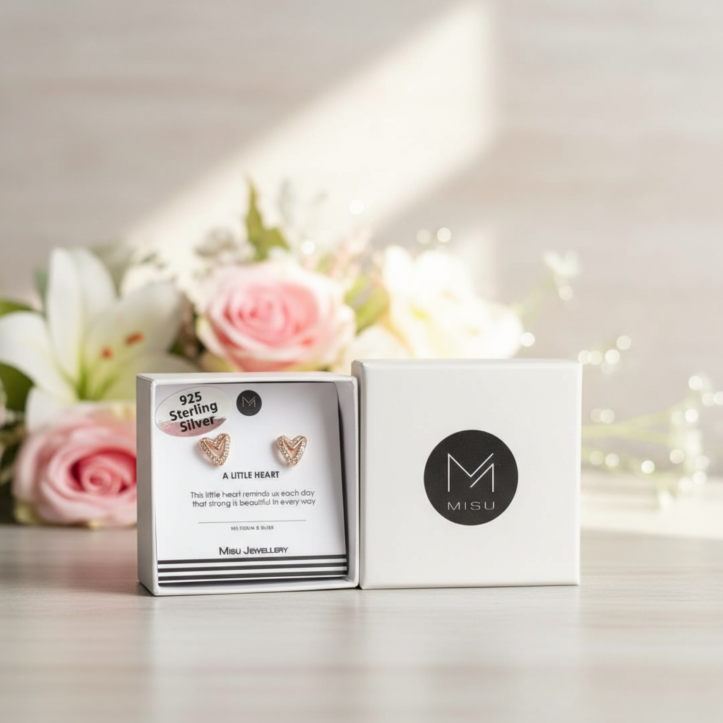 Misu Rosy Heart Stud Earrings featuring pink heart-shaped gemstones and silver posts on a white background