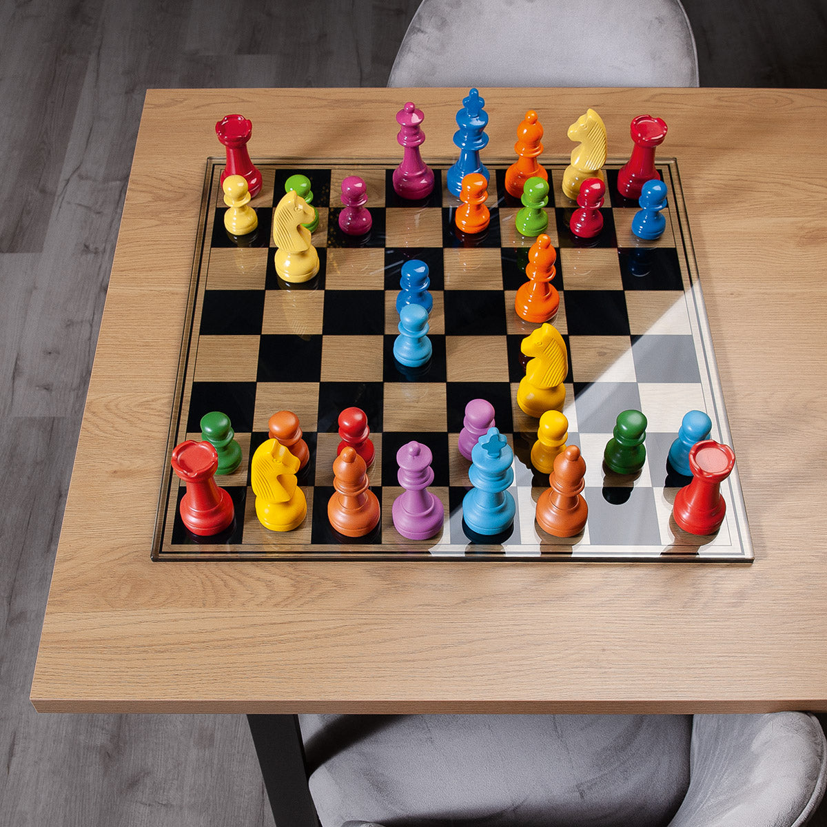 Multicolored Gilde glass chess set with detailed chess pieces on a playing board, ideal for collectors and chess enthusiasts.