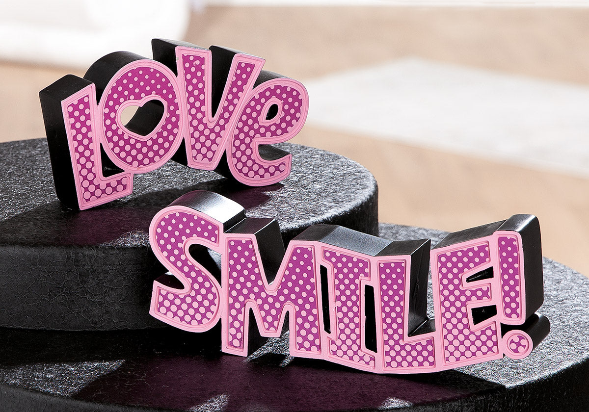Pink dotted lettering spelling "Love" by Gilde, decorative wall art with a stylish, modern design for home decor.