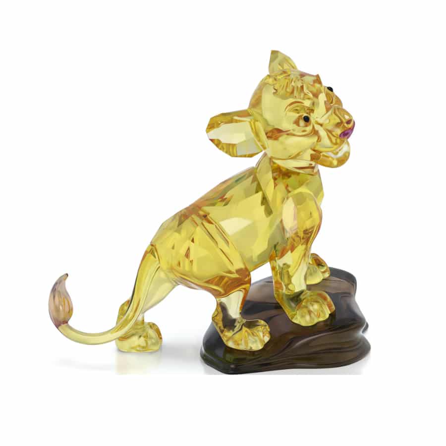 Swarovski The Lion King Simba figurine with detailed crystal craftsmanship and vibrant yellow and gold accents.