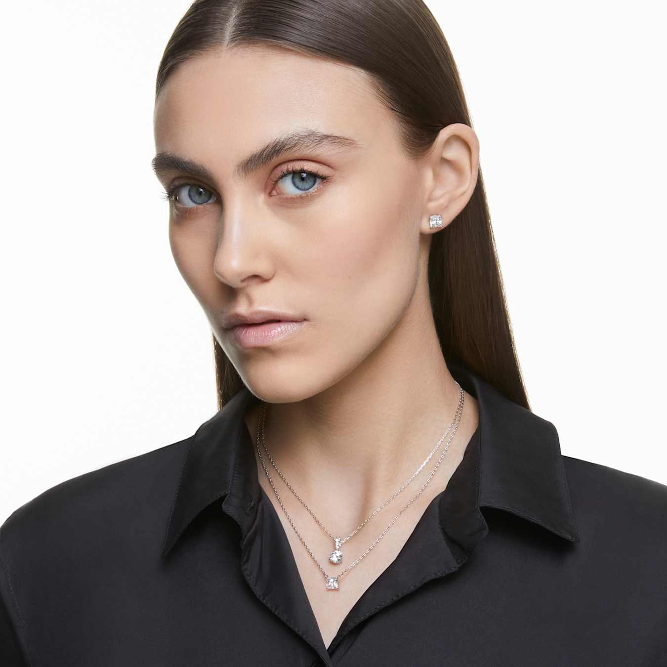 Swarovski Stilla Attract stud earrings with square-cut white crystals and rhodium-plated setting on a white background.