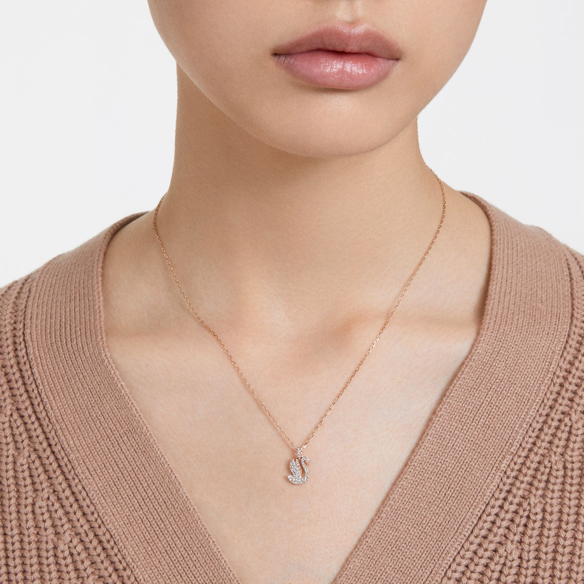 Small Swarovski Swan pendant in white with rose gold-tone plating, showcasing a delicate, elegant jewelry piece.