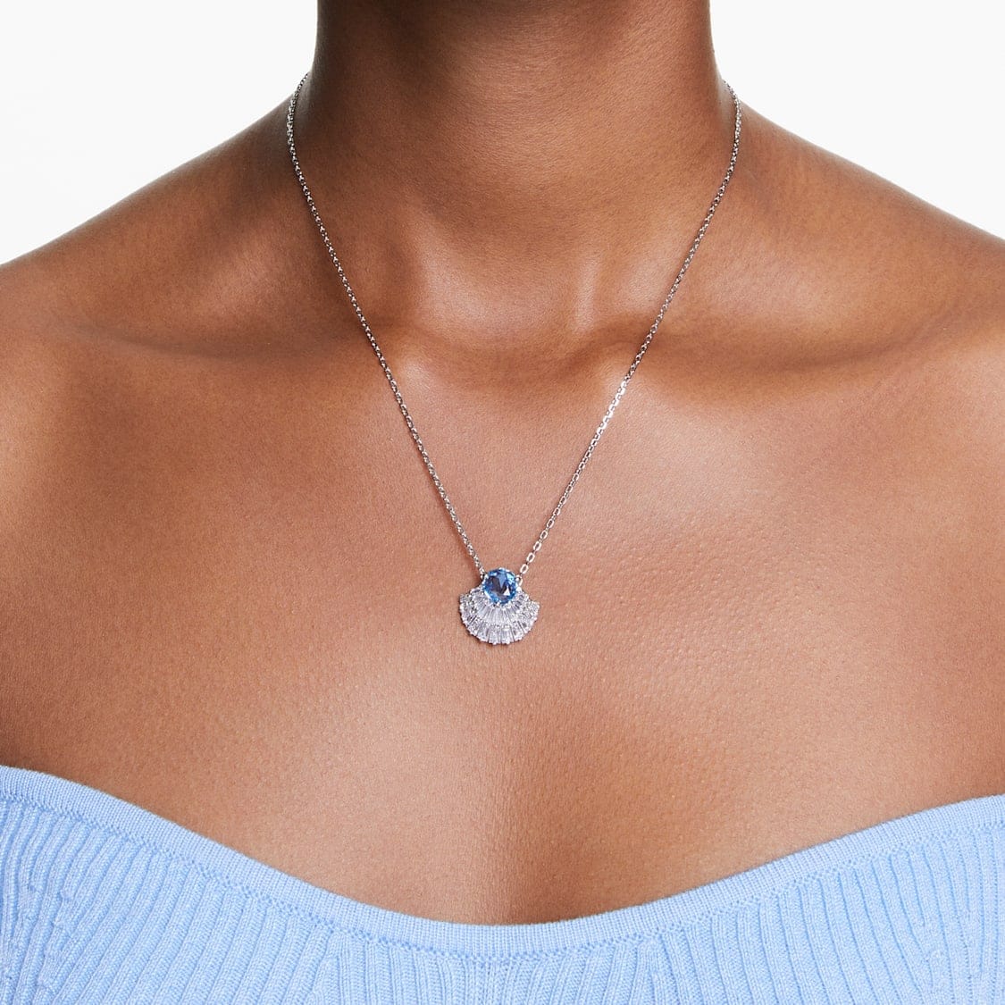 Swarovski Idyllia pendant with a shell-shaped blue crystal and rhodium-plated setting, elegant jewelry piece.
