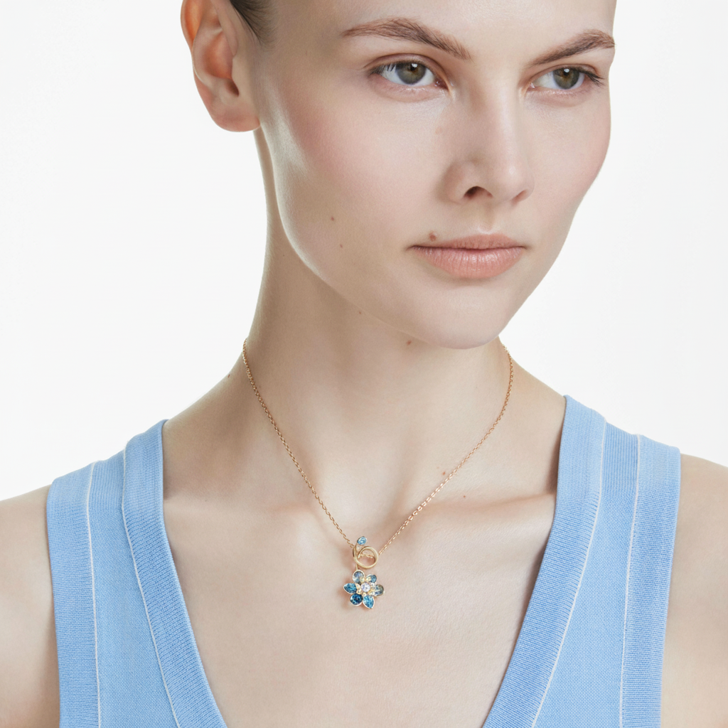 Swarovski Idyllia pendant with mixed cuts floral design in blue crystal, gold-tone plated jewelry piece.