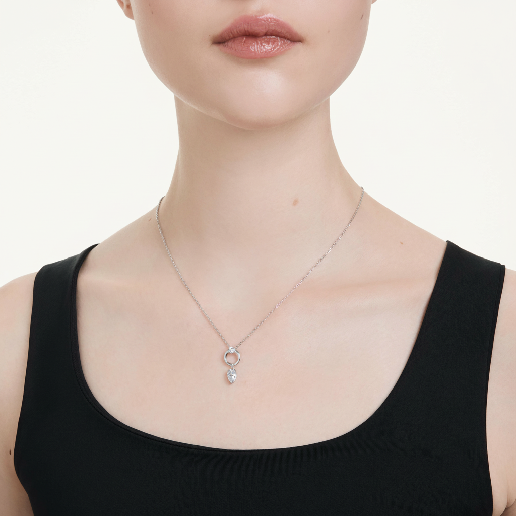 Swarovski Mesmera pendant with pear-shaped white crystal, rhodium-plated silver setting, elegant jewelry design.