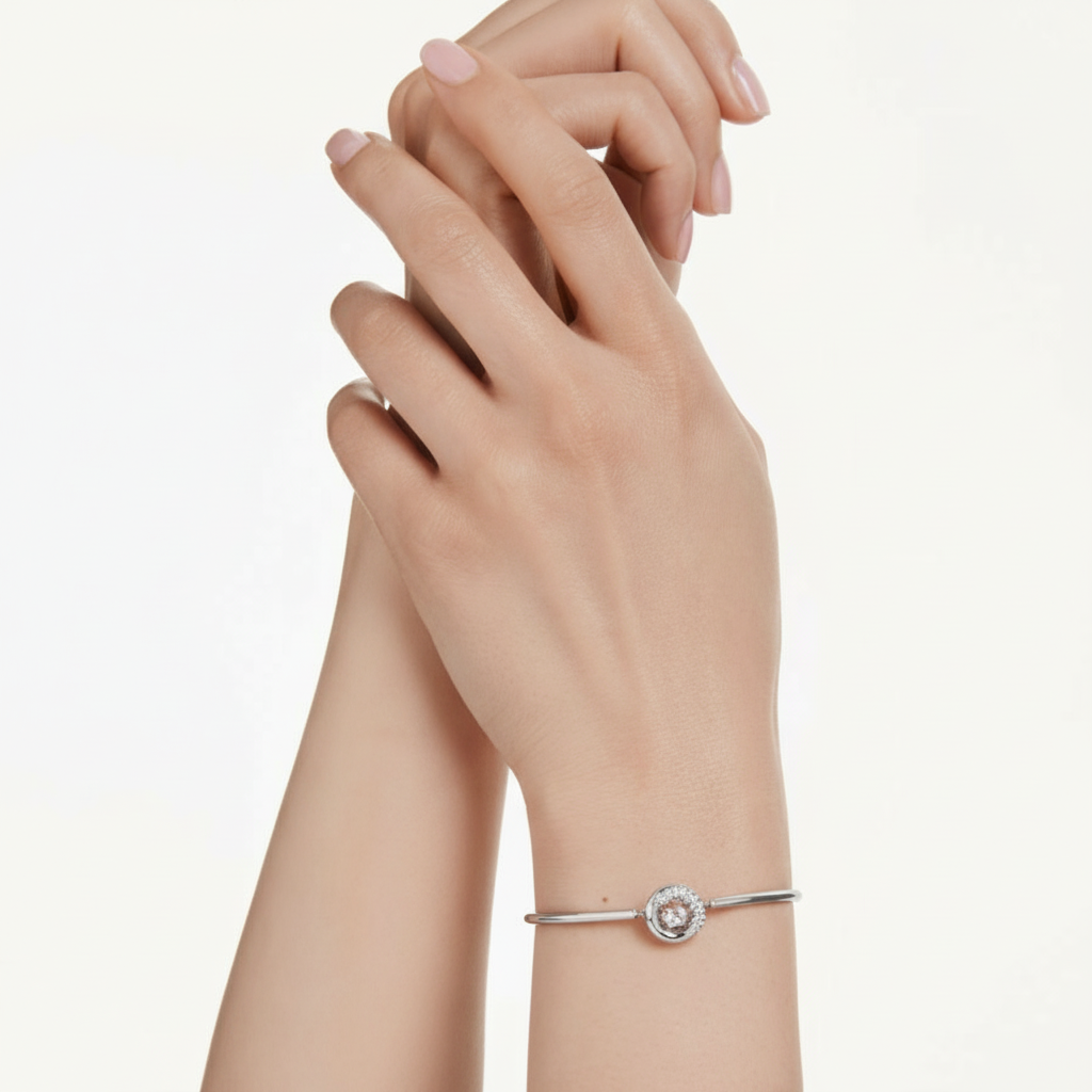 Swarovski Dextera bangle with round cut white crystals and rhodium plating, showcasing a sleek, elegant jewelry design.