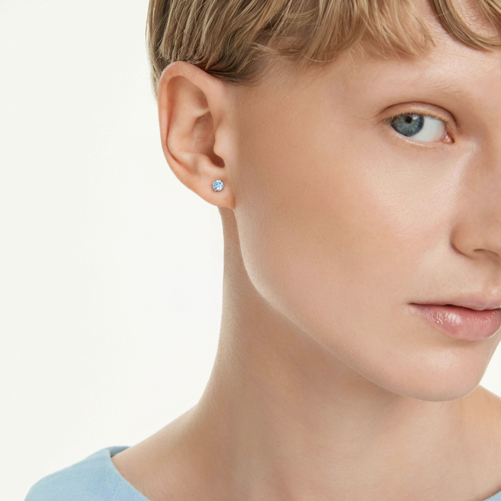Swarovski Stilla Attract stud earrings with round blue crystals and rhodium plating, showcasing elegant jewelry design.