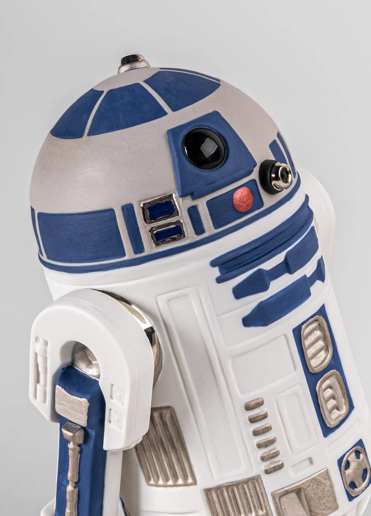 Lladro R2D2™ sculpture showcasing a detailed ceramic replica of the iconic Star Wars droid with white and blue finish.
