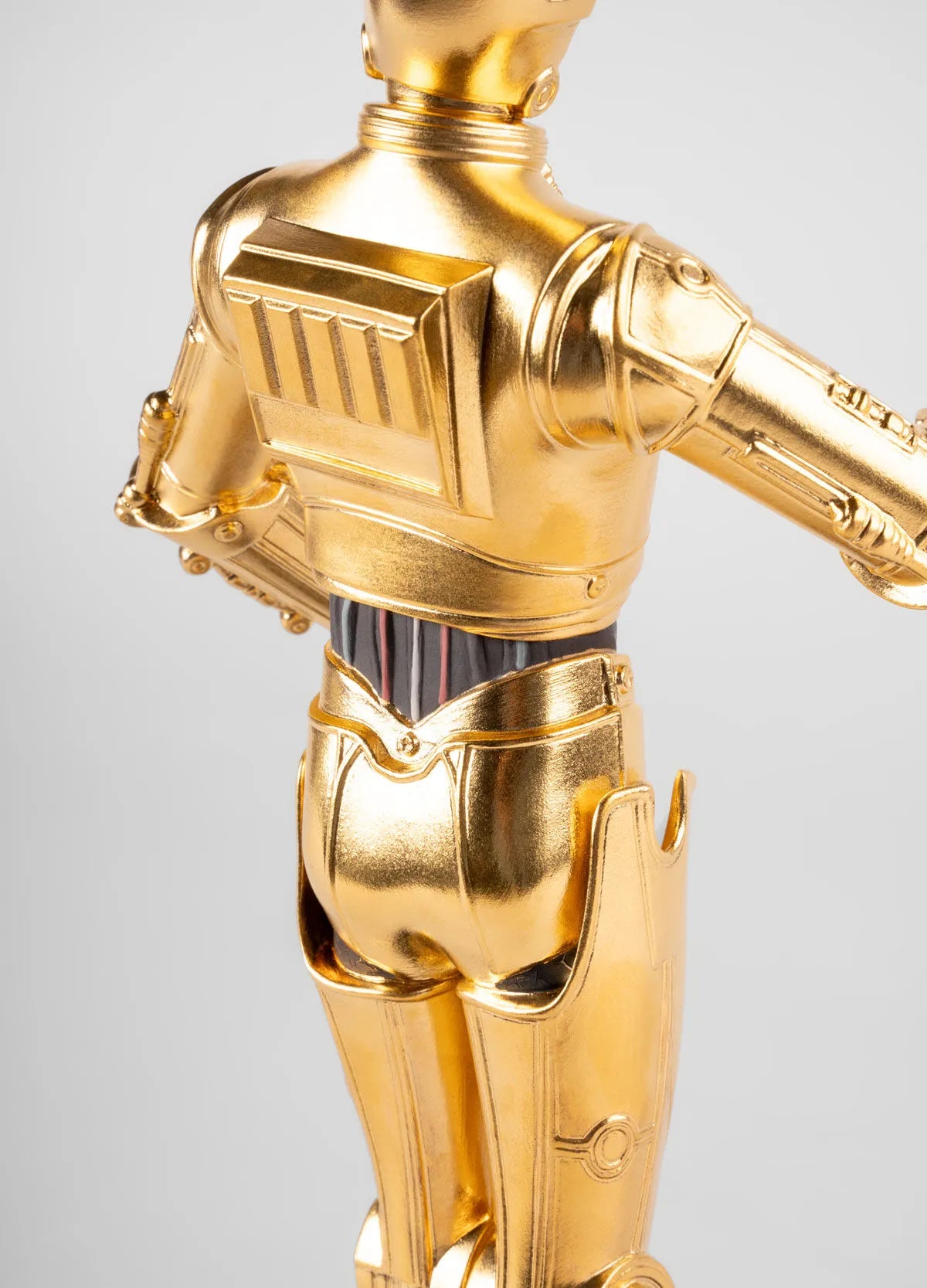 Lladro C3PO™ sculpture in glossy ceramic finish, detailed gold accents, showcasing the iconic Star Wars robot figure.