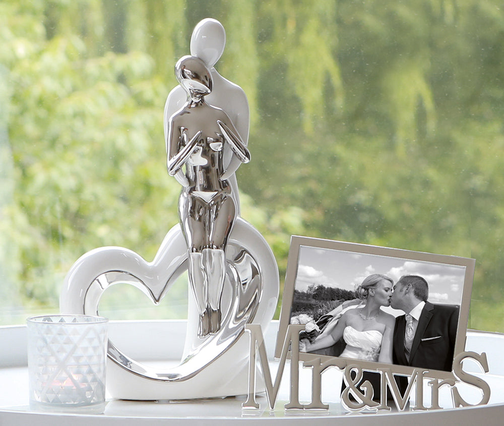 Pair of Gilde Romanze White and Silver sculptures featuring elegant, detailed figures on a decorative base.