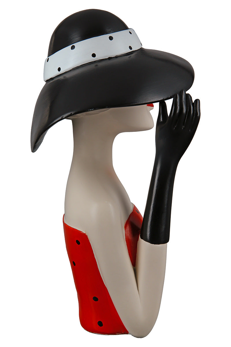 Gilde woman figure wearing a black hat with dotted details, showcasing elegant fashion pose and stylish accessories.