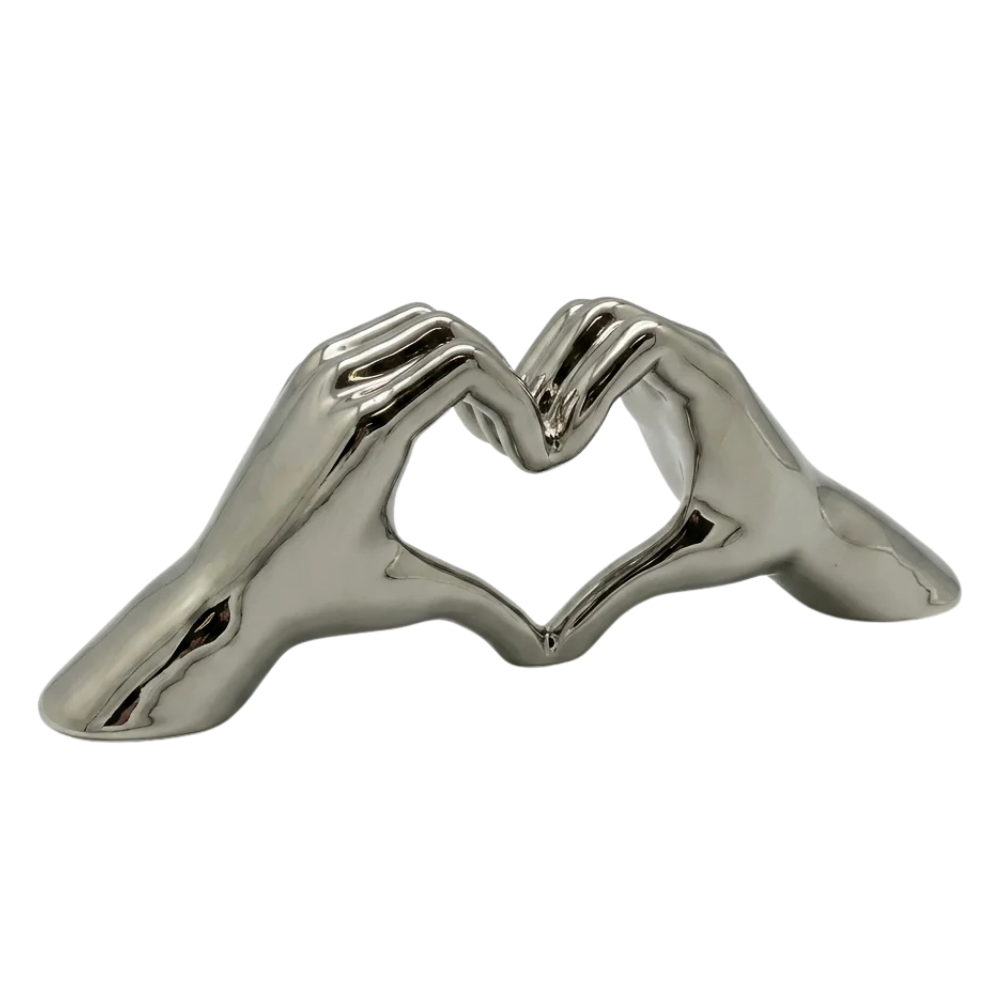 Silver decorative object shaped like a heart with hand motif by Gilde, featuring intricate design and artistic craftsmanship.