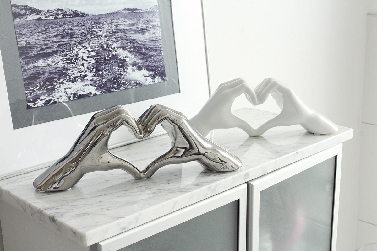 Silver decorative heart object with hand motif by Gilde, featuring intricate detailing and a modern design.