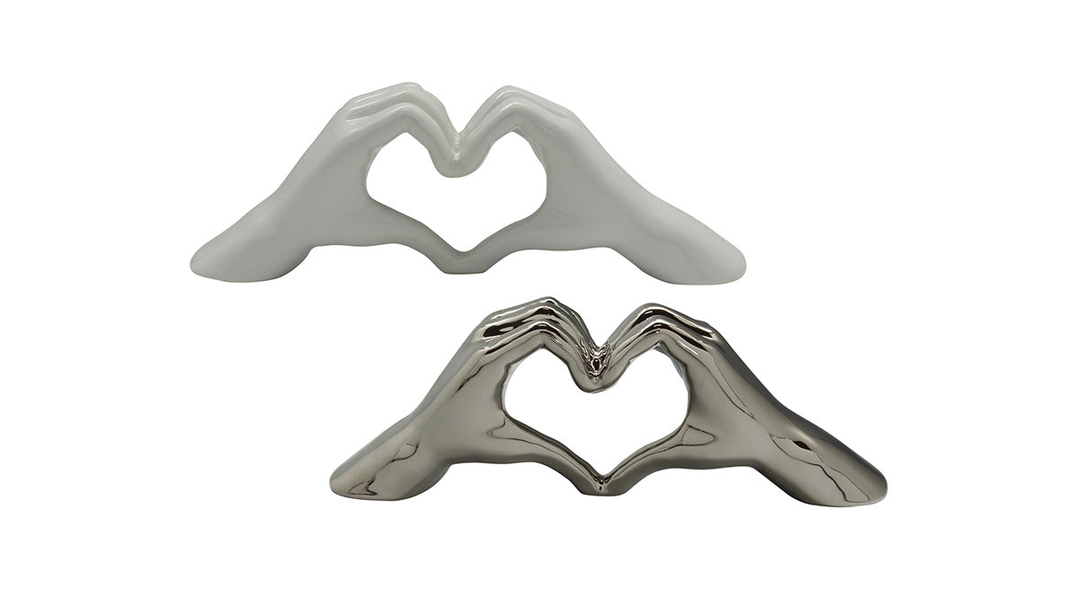 Silver decorative heart object with hand motif by Gilde, featuring intricate design and artistic craftsmanship.