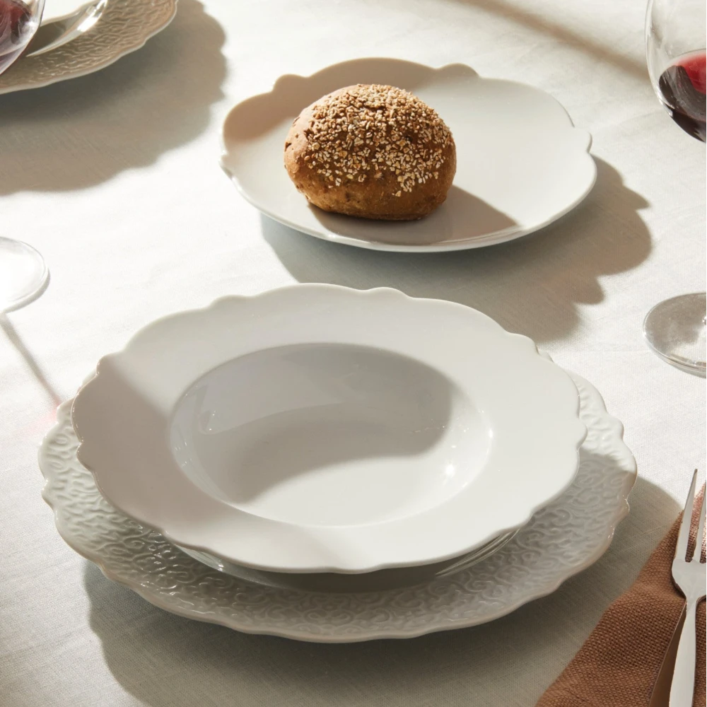 Alessi dressed porcelain dinner plate with elegant design, featuring a smooth white surface and classic shape for fine dining.